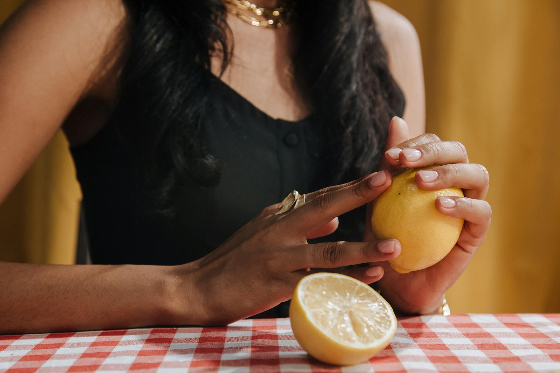Yellow silicone vibrator surrounded by fresh fruit on bright background